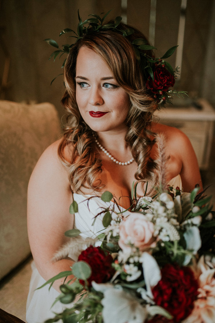 Bride holding a red and blush rose bridal bouquet wearing a matching red hearts rose floral crown.

