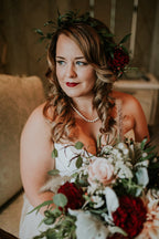Bride holding a red and blush rose bridal bouquet wearing a matching red hearts rose floral crown.
